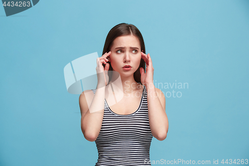 Image of Let me think. Doubtful pensive woman with thoughtful expression making choice against blue background