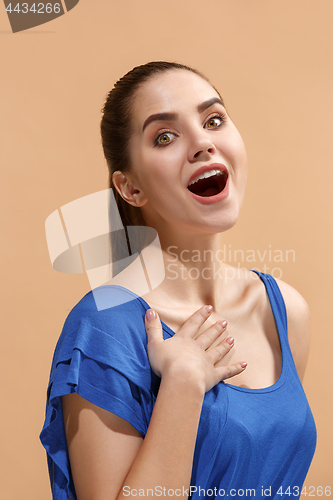 Image of The happy woman standing and smiling against pastel background.