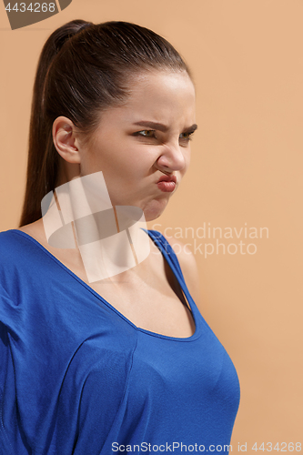 Image of The young woman is looking angry on thepastel background.