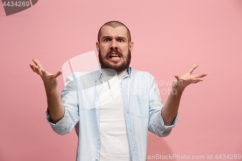 Image of Beautiful male half-length portrait isolated on pink studio backgroud. The young emotional surprised man