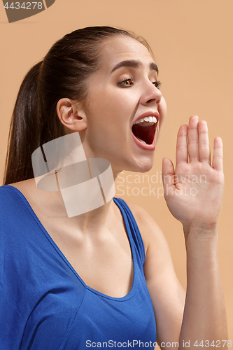 Image of The young woman is calling on the pastel background.