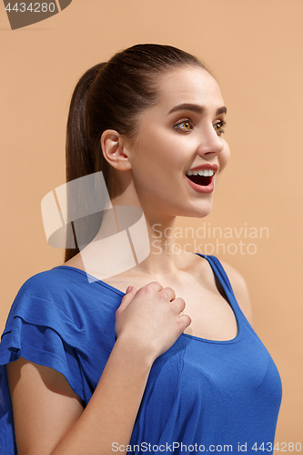 Image of The happy woman standing and smiling against pastel background.