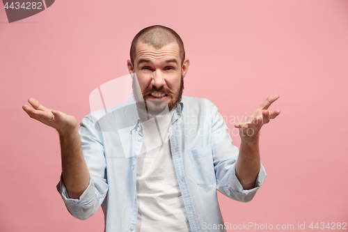 Image of Beautiful male half-length portrait isolated on pink studio backgroud. The young emotional surprised man