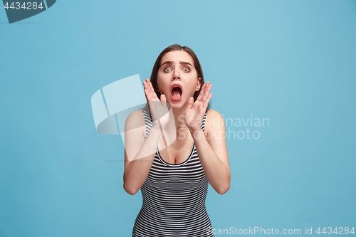 Image of Isolated on blue young casual woman shouting at studio