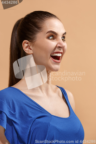 Image of The happy woman standing and smiling against pastel background.