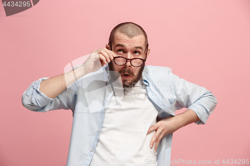 Image of Let me think. Doubtful pensive man with thoughtful expression making choice against pink background