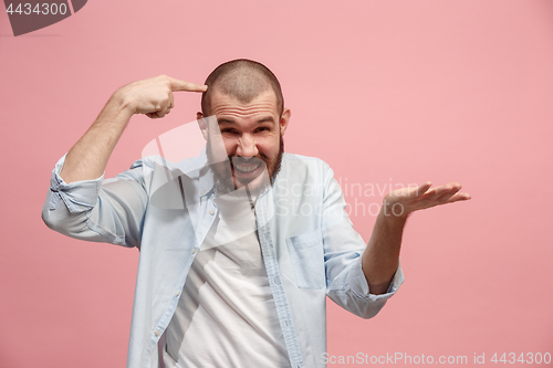 Image of Beautiful male half-length portrait isolated on pink studio backgroud. The young emotional surprised man