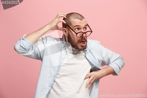 Image of Let me think. Doubtful pensive man with thoughtful expression making choice against pink background