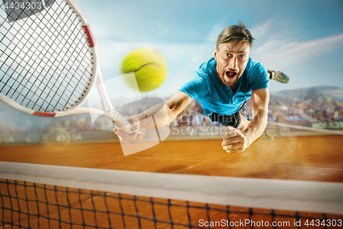 Image of The one jumping player, caucasian fit man, playing tennis on the earthen court with spectators