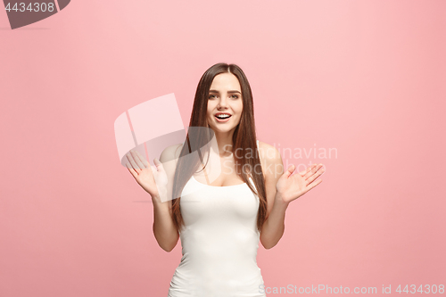 Image of The happy business woman standing and smiling against pink background.