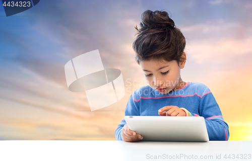 Image of little girl with tablet pc over evening sky