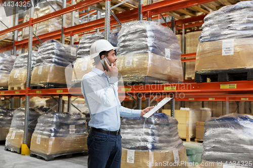 Image of businessman calling on smartphone at warehouse