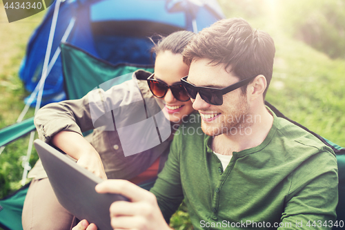 Image of happy couple with tablet pc at camping tent
