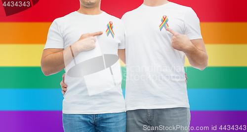 Image of close up of couple with gay pride rainbow ribbons