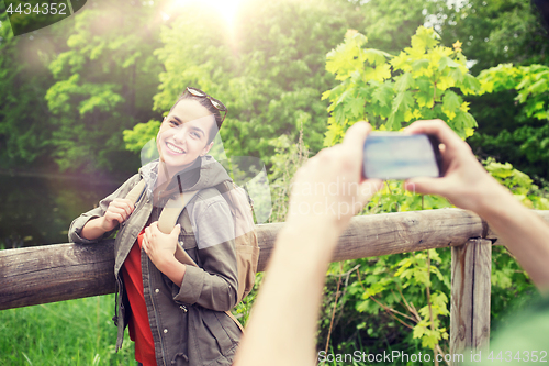 Image of couple with backpacks taking picture by smartphone