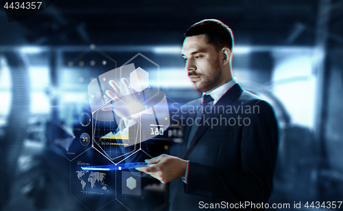 Image of businessman with transparent tablet and charts