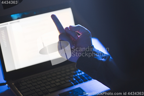 Image of hacker showing middle finger to laptop