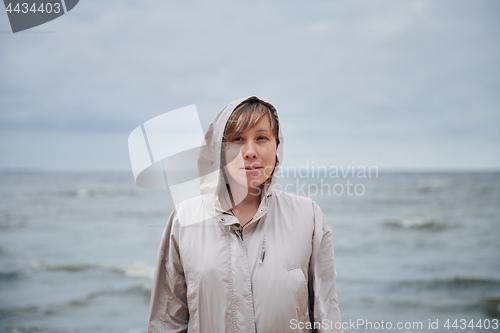 Image of Smiling young woman standing near sea