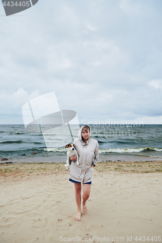 Image of Young lady with dog near sea