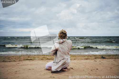 Image of Anonymous woman in jacket looking at sea