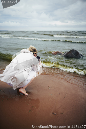 Image of Unrecognizable woman taking picture of waving sea