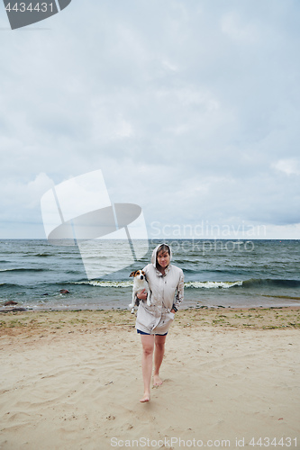 Image of Young lady with dog near sea