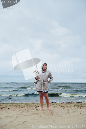 Image of Young lady with dog near stormy sea