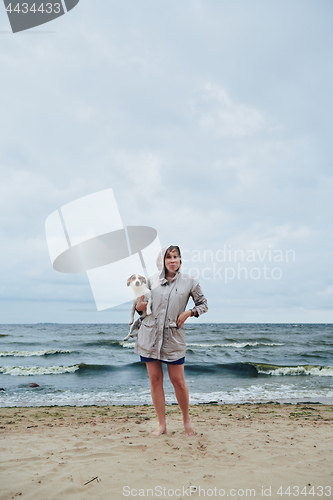 Image of Young lady with dog near stormy sea