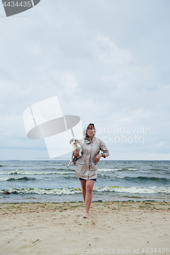 Image of Young lady with dog near stormy sea