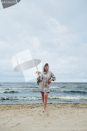 Image of Young lady with dog near stormy sea