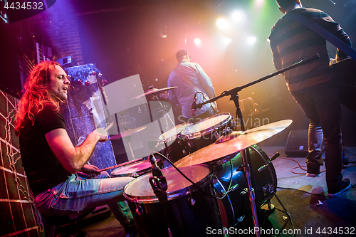 Image of Drummer playing on drum set on stage.