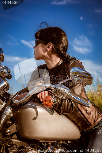 Image of Biker girl sitting on motorcycle