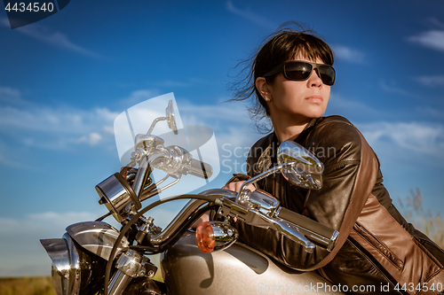 Image of Biker girl sitting on motorcycle