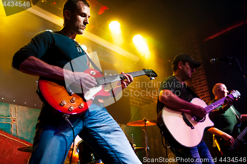 Image of Band performs on stage in a nightclub