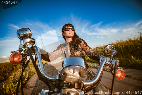 Image of Biker girl sitting on motorcycle