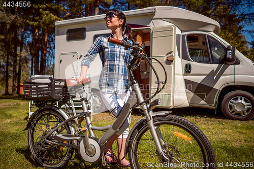 Image of Woman on electric bike resting at the campsite VR Caravan car Va