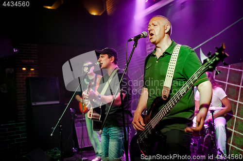 Image of Band performs on stage in a nightclub