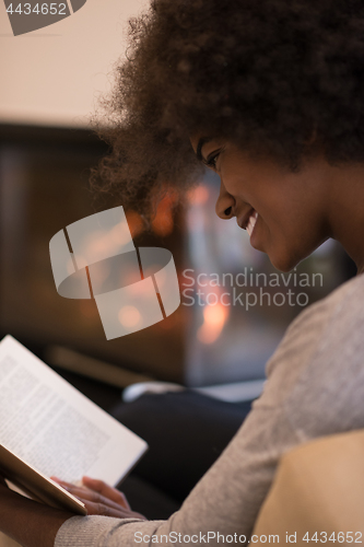 Image of black woman at home reading book