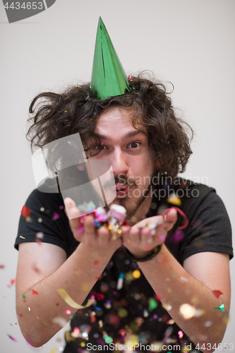 Image of man blowing confetti in the air