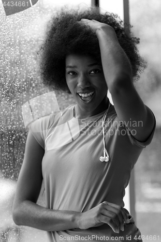 Image of portrait of young afro american woman in gym while listening mus