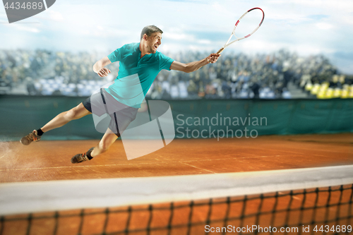 Image of The one jumping player, caucasian fit man, playing tennis on the earthen court with spectators