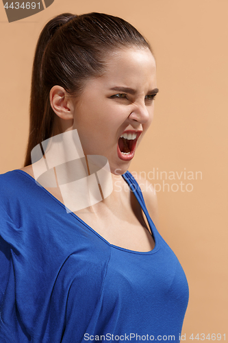 Image of The young emotional angry woman screaming on pastel studio background