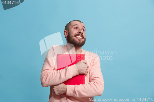 Image of Businessman hugging laptop at studio
