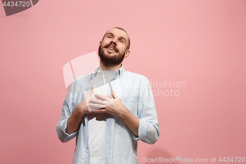 Image of The happy businessman standing and smiling against pink background.
