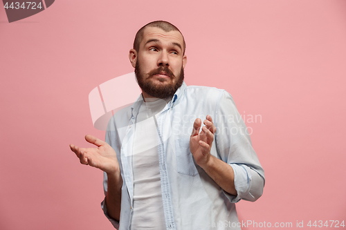 Image of Let me think. Doubtful pensive man with thoughtful expression making choice against pink background