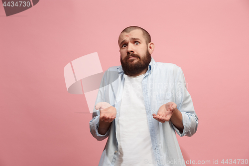 Image of Let me think. Doubtful pensive man with thoughtful expression making choice against pink background