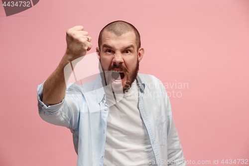 Image of The young emotional angry man screaming on pink studio background