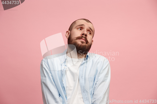 Image of Let me think. Doubtful pensive man with thoughtful expression making choice against pink background