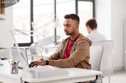 Image of indian man with laptop computer at office