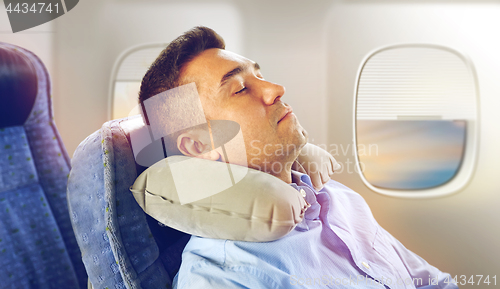 Image of man sleeping in plane with cervical neck pillow